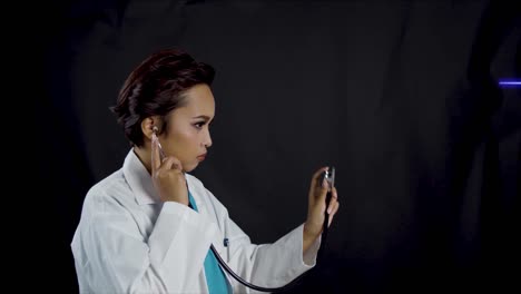 Female-doctor-holds-up-a-stethoscope-in-a-profile-view-as-if-checking-a-patient's-heartbeat-while-an-EKG-signal-is-displayed---copy-space