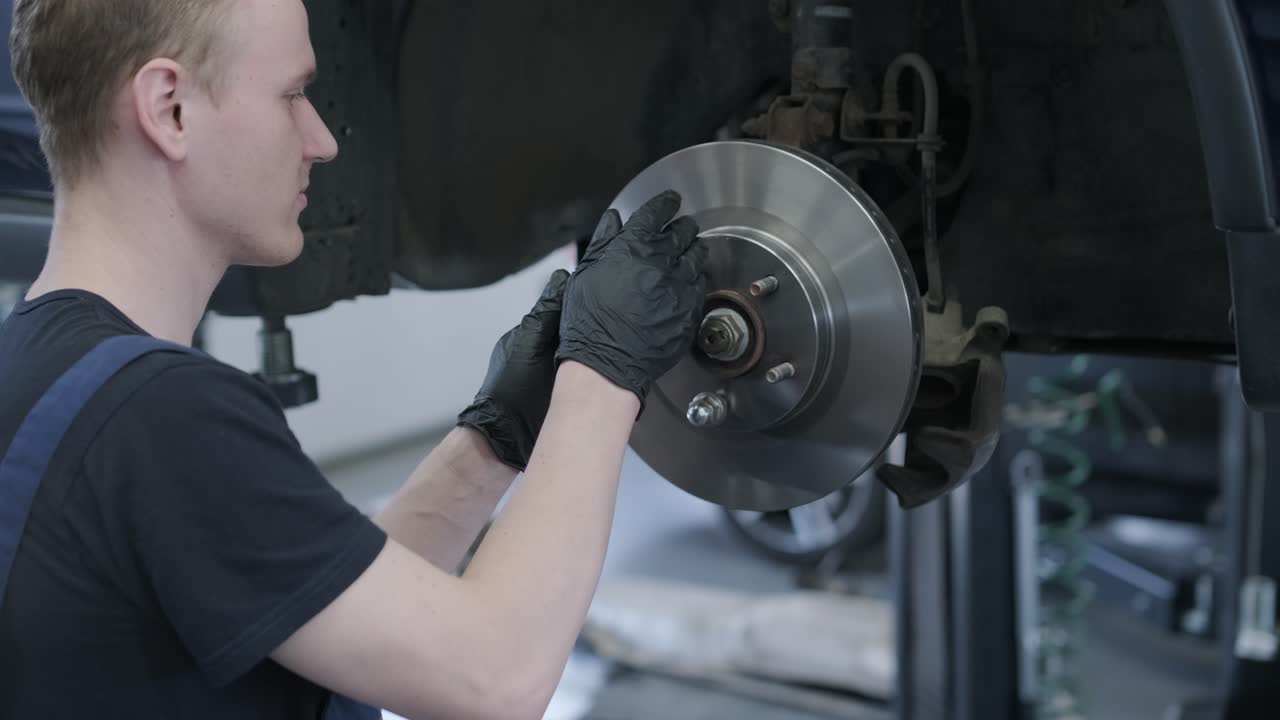 автомеханик, ремонтирующий тормоза