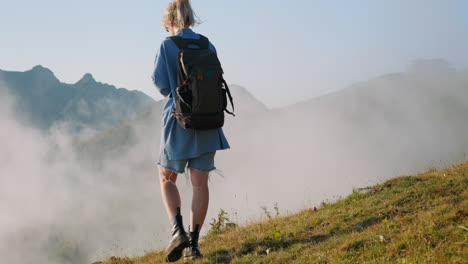 una mujer caminando por las montañas de niebla.