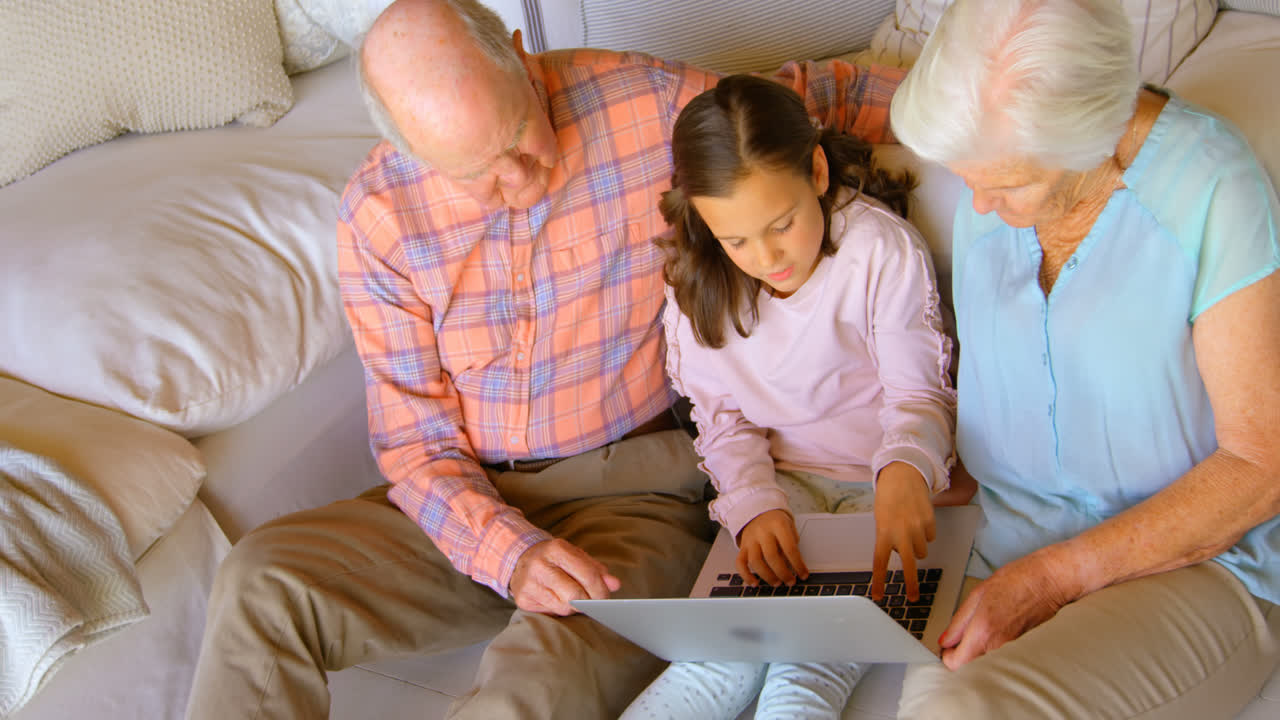 High angle view of Caucasian multi-generation family using laptop in a comfortable home 4k