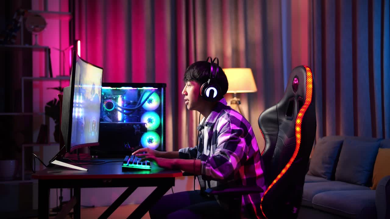 Excited Asian Teen Boy Gamer Playing Video Game On Computer