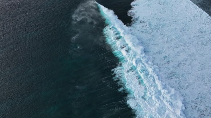 One Eye wave breaking near sea shore at Mauritius, aerial push-in