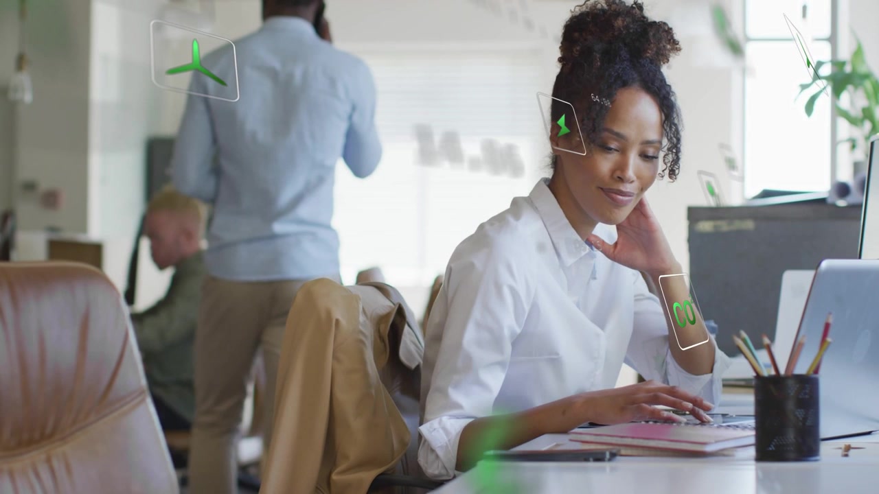 Woman responding to green HUD notification on laptop, typing while tracking business data