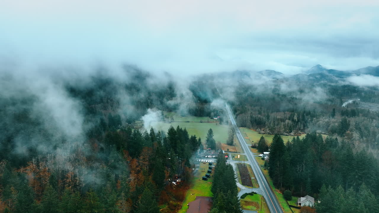 Mountain road with foggy landscapes. Aerial morning foggy road in forest.