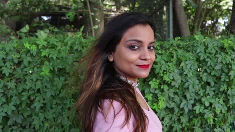 wind blowing the hair of a beautiful indian woman smiling and looking at the camera