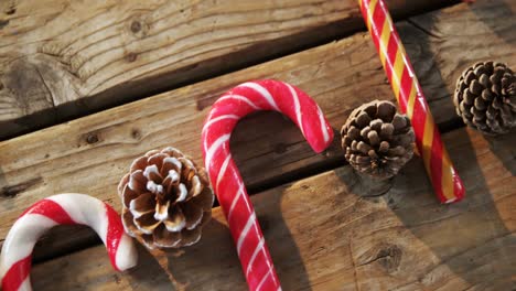 candy cane with pine cone on wooden table 4k