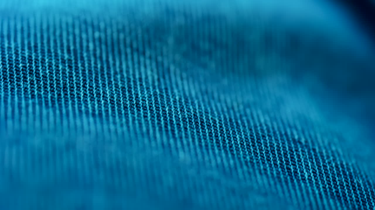 Close up of blue fabric texture showing fine threads and detailed textile pattern