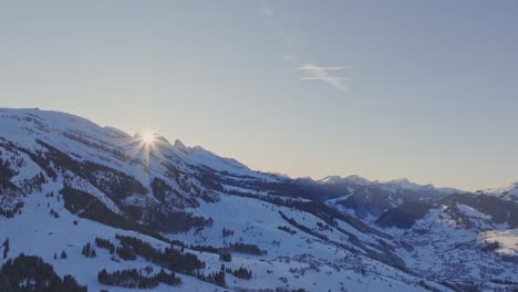 silhouette of a snowy mountain range illuminated by the dawn sunlight