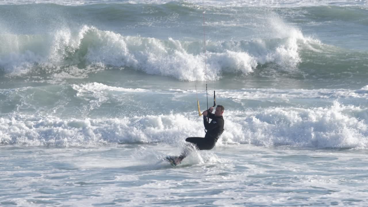 Kitesurfer rides the waves on a windy day in Cape Town's Big Bay with scenic ocean backdrop