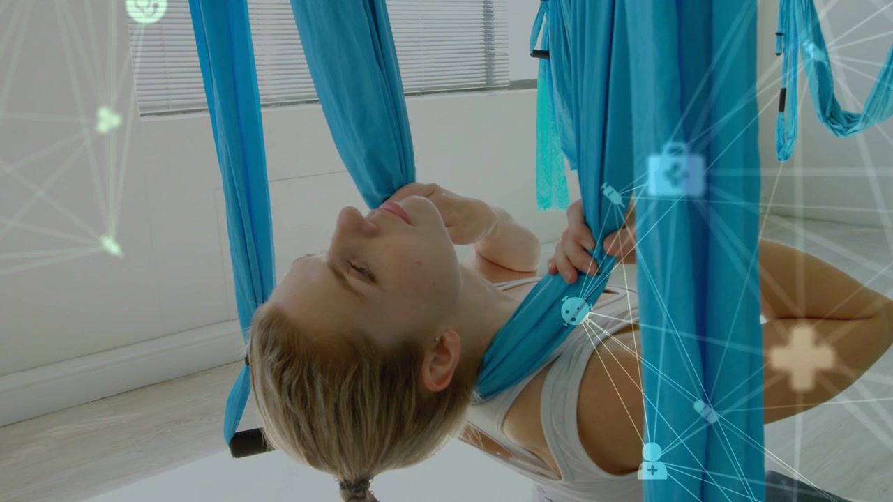 Woman in fitness hub pulling silk under neck, balancing stretch while icons partly overlaying her