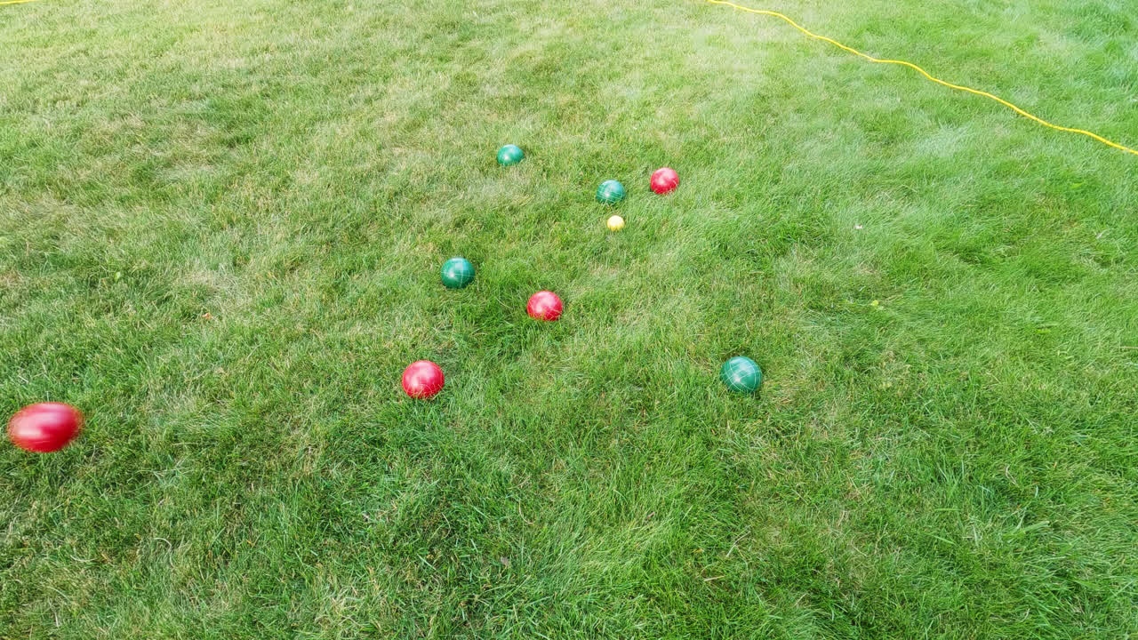 표적에 대한 전통적인 부울 게임을 하는 동안 땅에 던져진 붉은 중금속 공의 개요 샷