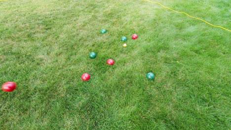 toma general de una bola roja de metal pesado arrojada al suelo mientras jugaba al juego tradicional de petanca en el objetivo