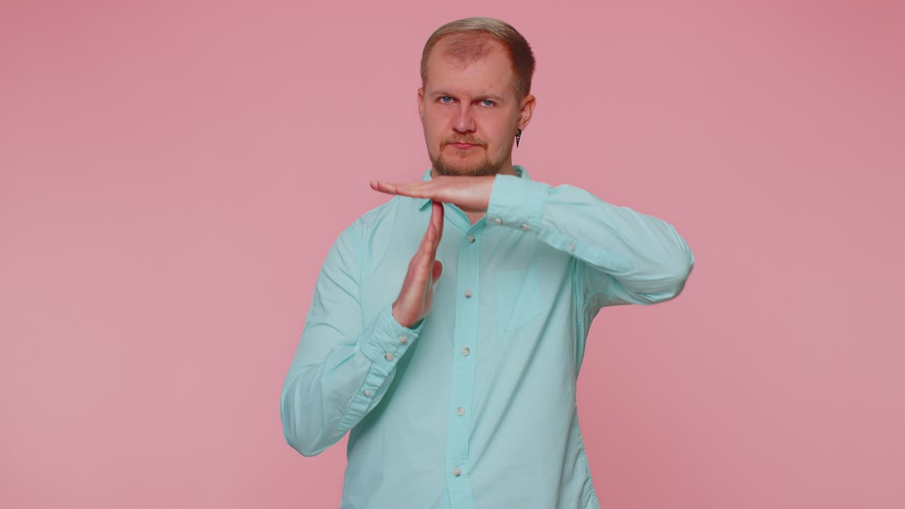 Tired serious upset man showing time out gesture limit stop break sign no pressure i need more time