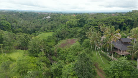 Low-flying-aerial-dolly-shot-of-a-luxury-resort-villas-hidden-in-the-dense-green-rainforests-of-Bali