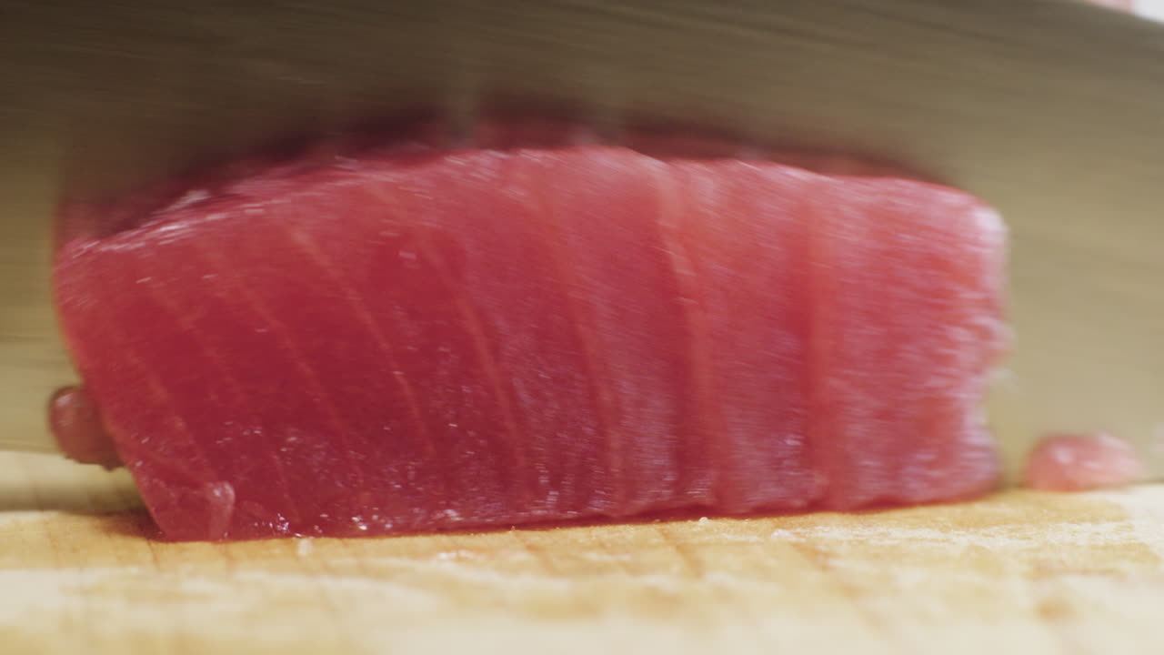 Atún crudo siendo rebanado para usar en sushi y sashimi
