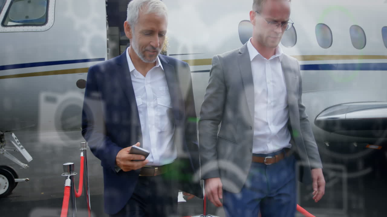 animación de iconos digitales y procesamiento de datos sobre hombres de negocios que salen del avión en el aeropuerto