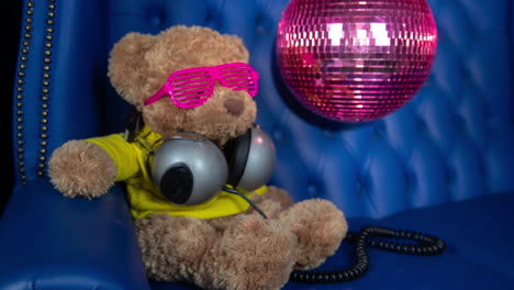 teddy bear dj in a blue chair with disco ball