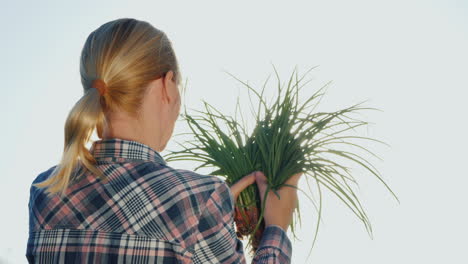 woman farmer holds bunch of green onions vitamins from the farm