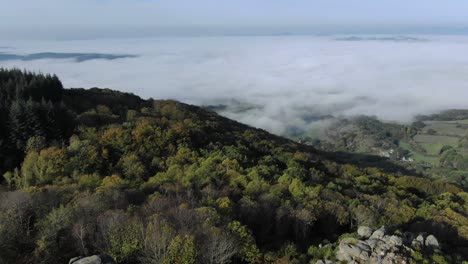 Vista-Aérea-De-Drones-Desde-La-Montaña-Uchon-Con-Paisaje-Rural-Envuelto-En-Niebla-En-El-Fondo,-Departamento-De-Saone-et-loire-En-Francia