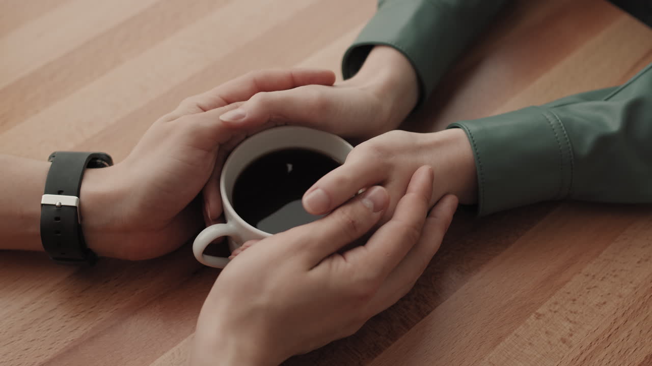 커피하우스에서 손을 잡고 있는 인식할 수 없는 남자와 여자