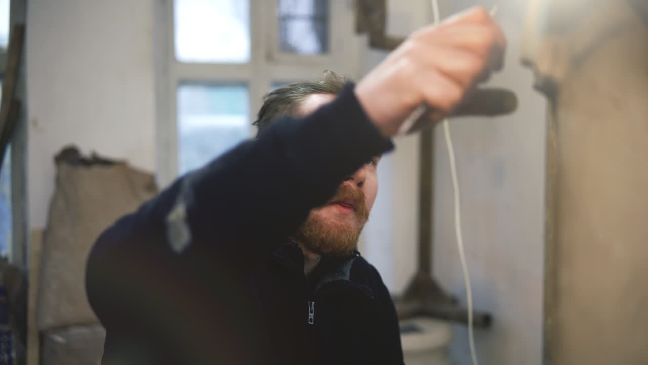 artista trabajando en la estatua de buda usando una herramienta especial en el taller