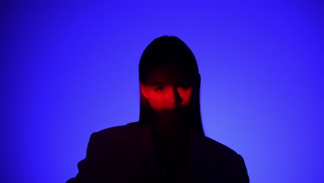 mysterious person in dramatic blue and red lighting effect a person is captured in dramatic lighting featuring vivid blue and red shadows creating a mysterious and intriguing visual effect
