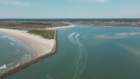 Vista-Aérea-Que-Muestra-Lanchas-Rápidas-Que-Salen-Del-Puerto-En-La-Desembocadura-Del-Río-Murrells-Inlet-Durante-La-Luz-Del-Sol