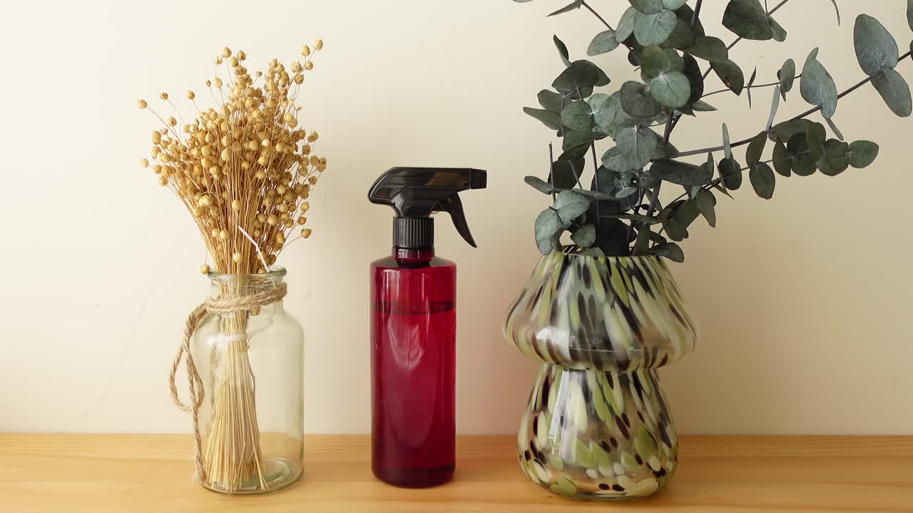 Still life with spray bottle and flower arrangements