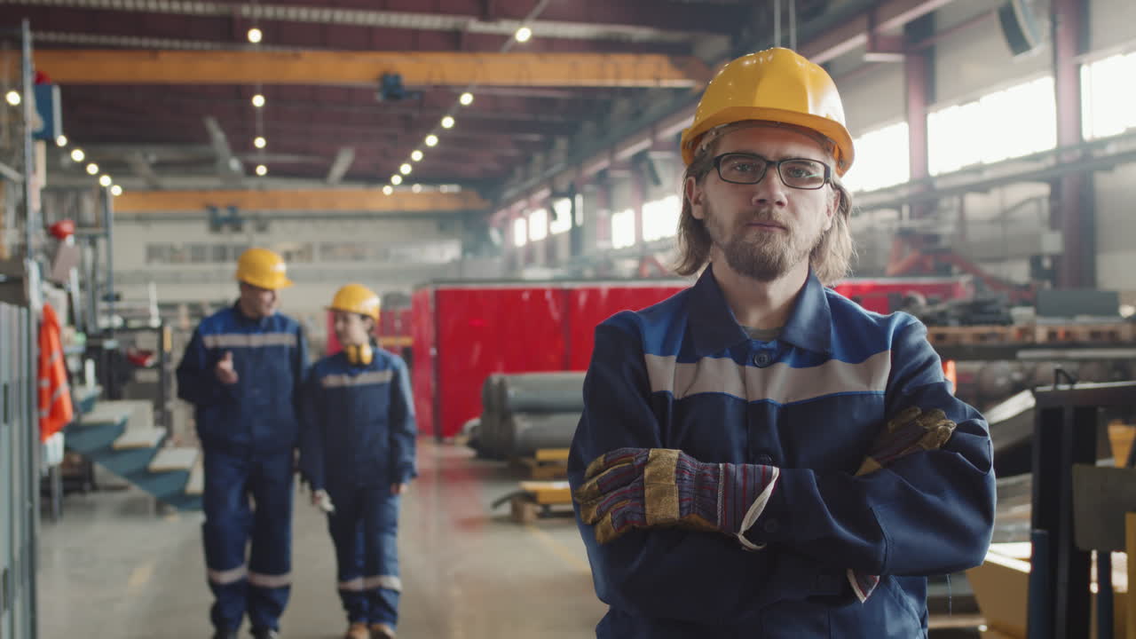 Operaio in fabbrica in posa per la fotocamera sul posto di lavoro
