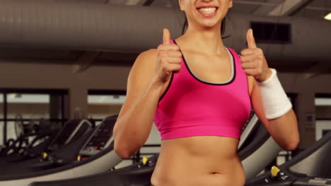 mujer en forma sonriente gestando los pulgares hacia arriba