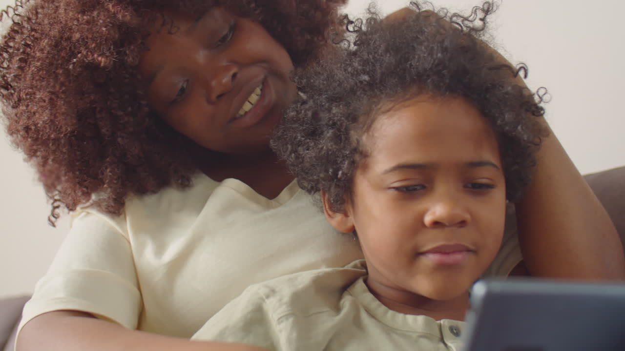 Happy African American Mom and Kid Using Tablet at Home