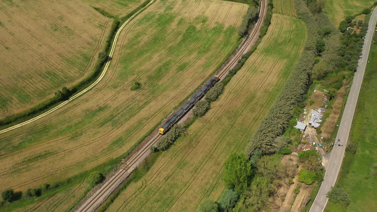 Aerial shot following Train running on evergreen countryside Road rails, Portugal