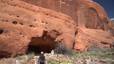 Back-of-Woman-Entering-Cave-in-Sandstone-Cliff,-Hole-N''-Rock-Attraction-Near-Moab-Utah-USA