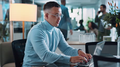 hombre trabajando en una computadora portátil en una oficina moderna