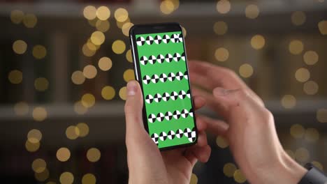man uses smartphone with alpha compositing in closeup against bokeh background