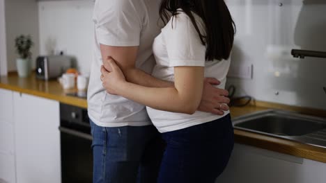 Mujer-Embarazada-Despreocupada-Bailando-Con-Un-Hombre-Amoroso-En-La-Cocina-De-Casa