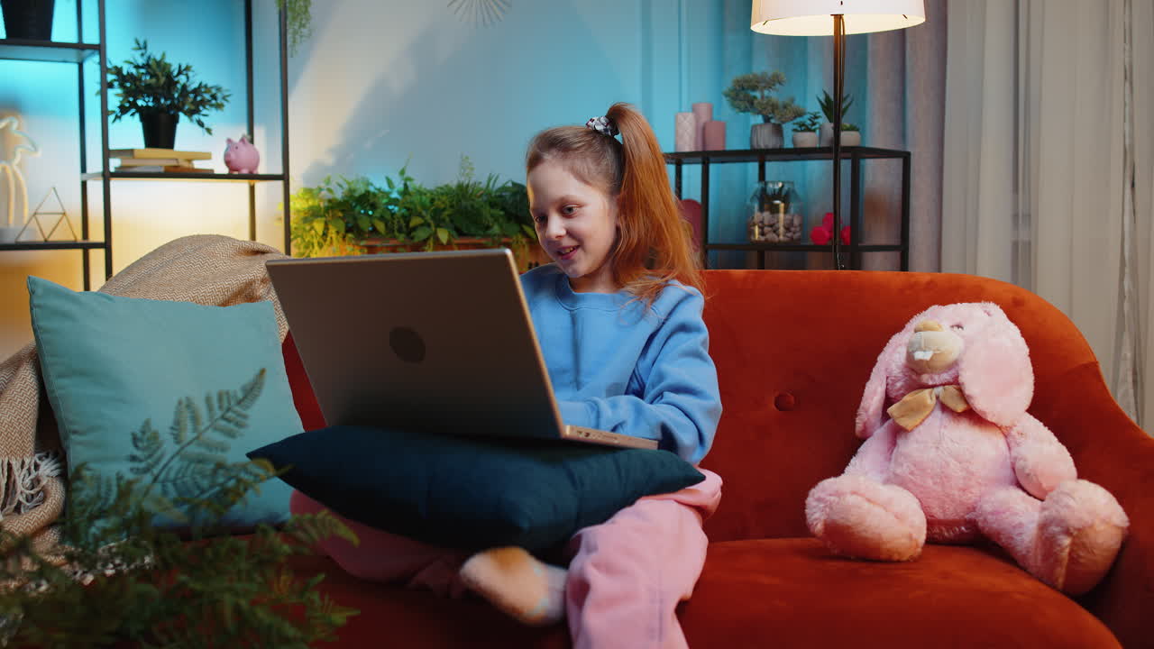 Preteen child girl looking at laptop camera making video webcam conference call with friends family