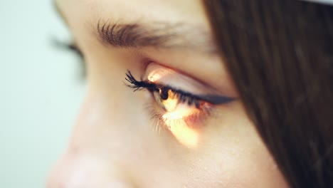 side view of woman's eye. laser shining into the eye of a patient during eyes examination. close-up. eyesight concept.