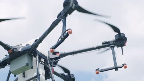 drone sprayer flies over the agricultural field. agriculture drone for spraying fertilizer on the blue sky. smart farming and precision agriculture