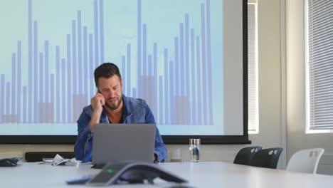 Front-view-of-young-caucasian-businessman-talking-on-mobile-phone-in-modern-office-4k