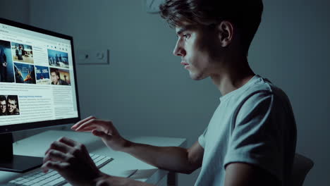 young man using computer at night