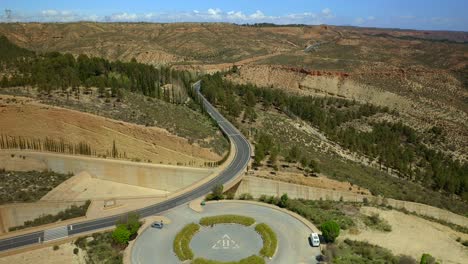 drone view of roadway running through mountainous terrain