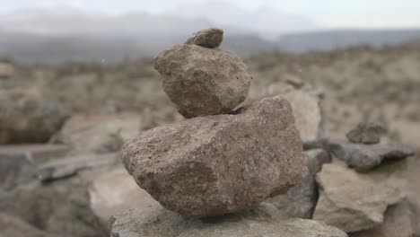 coropuna vulcan cairn stones hit by snow flakes in slow motion.
