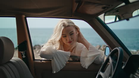 woman looking out of car window at the beach