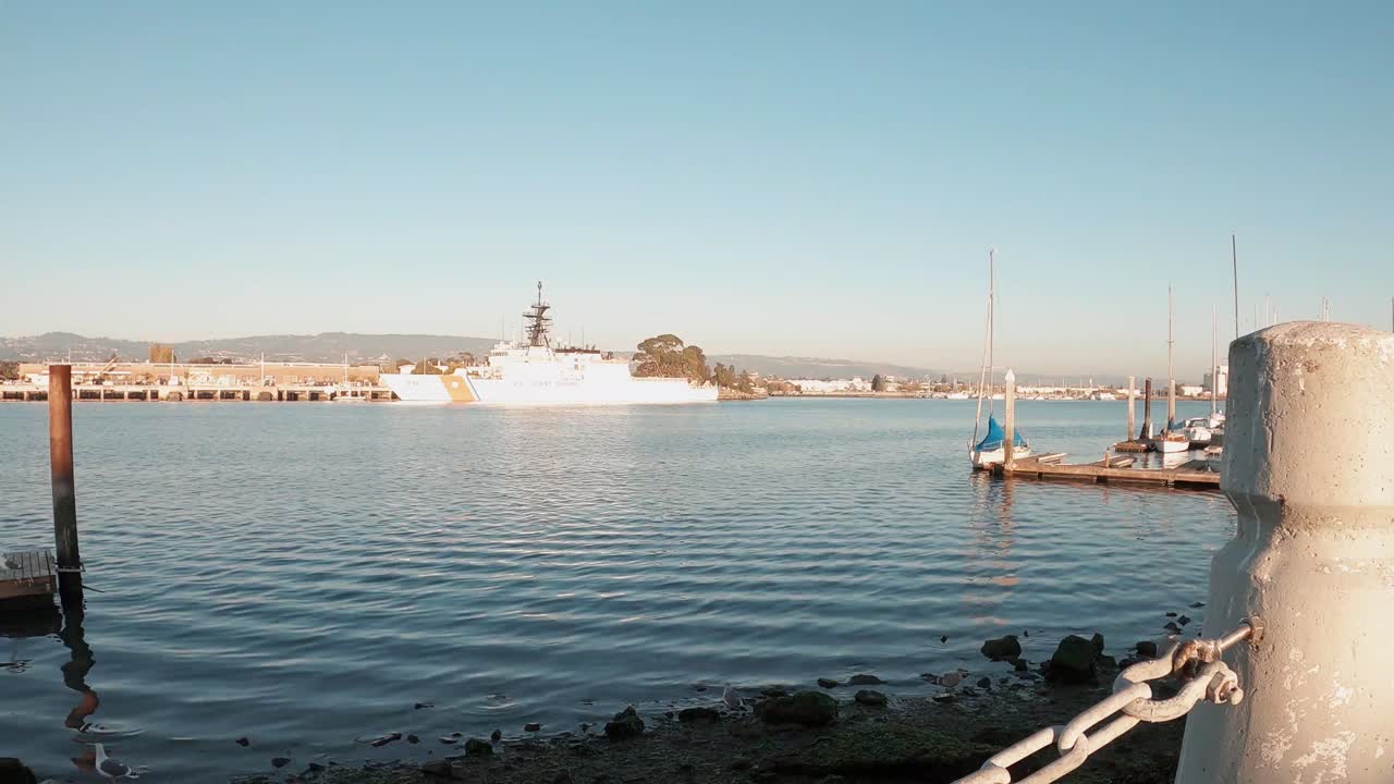 Coast Guard ships in the bay near the island headquarters on a sunny day.