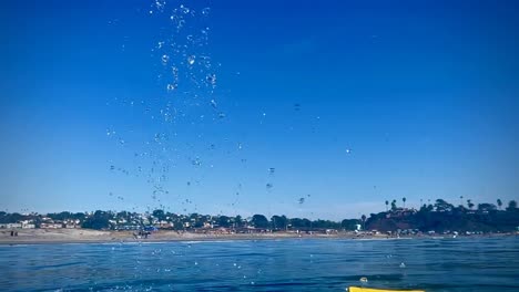 Schwimmflosse-Wirft-Wasser-Hoch-Und-Tröpfchen-Fallen-In-Zeitlupe-Beim-Schwimmen-In-Südkalifornien