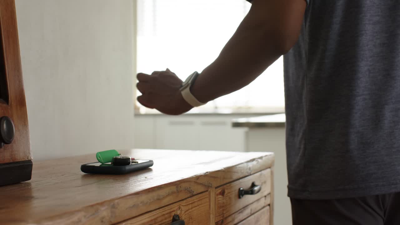 Hand is entering from left, placing smartphone and green item on island, then walking toward window
