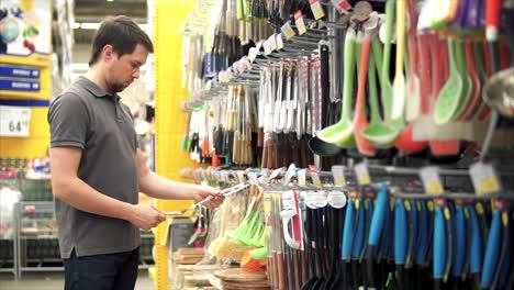 hombre comprando utensilios de cocina en un supermercado