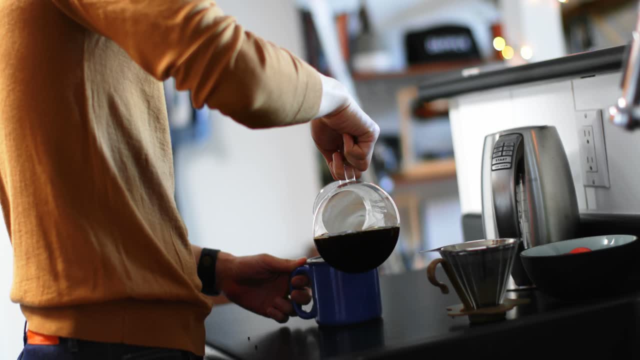 hombre vertiendo café de un frasco de vidrio en una taza de café 4k