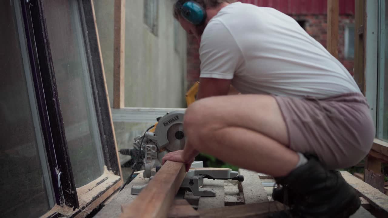 un hombre está utilizando una sierra circular para cortar la madera para la construcción del invernadero en indre fosen, condado de trondelag, noruega - de cerca